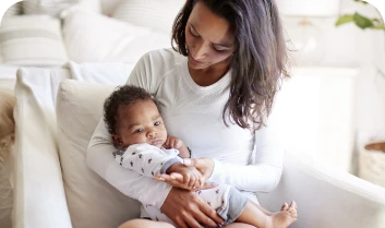 woman-holds-infant-in-a-bright-home-setting